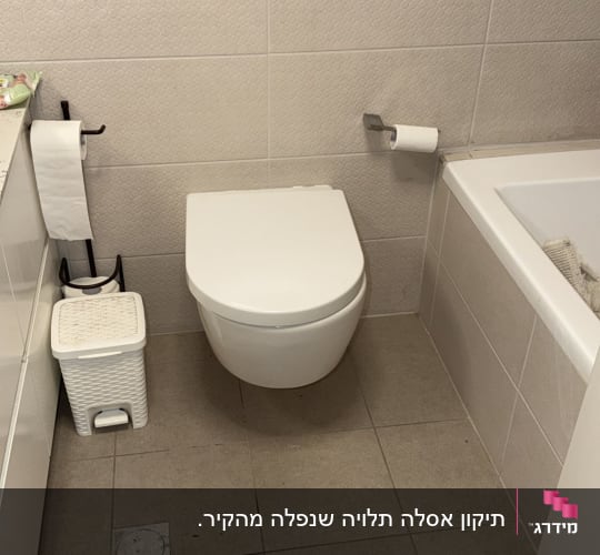 אסלה תלויה ולחצן ניאגרה סמויה בחדר רחצה מרוצף ומחופה